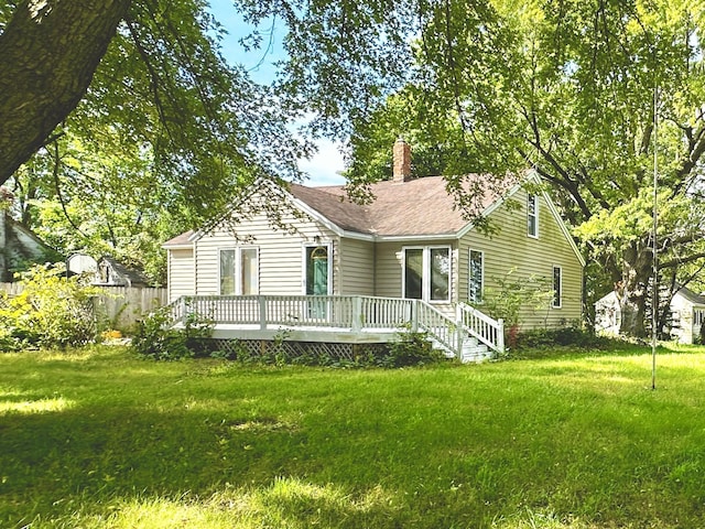 view of front of home with a front yard and a deck