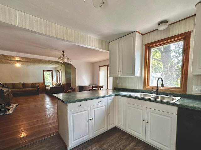 kitchen featuring sink, white cabinetry, dishwasher, kitchen peninsula, and dark wood-type flooring