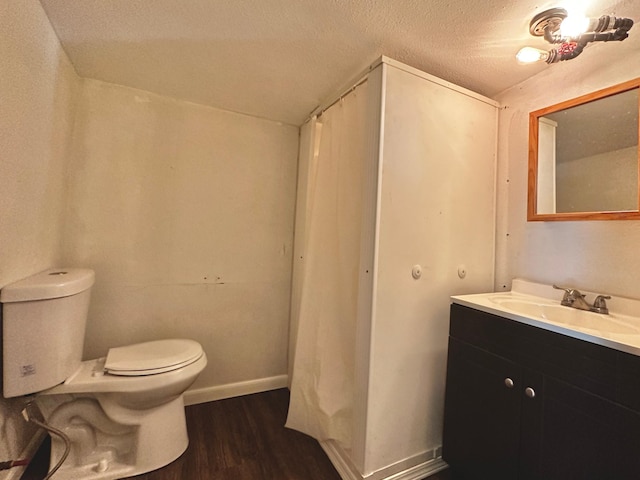 bathroom with toilet, a textured ceiling, vanity, and hardwood / wood-style floors