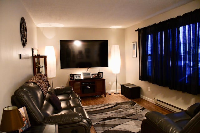 living room with hardwood / wood-style flooring and a baseboard heating unit