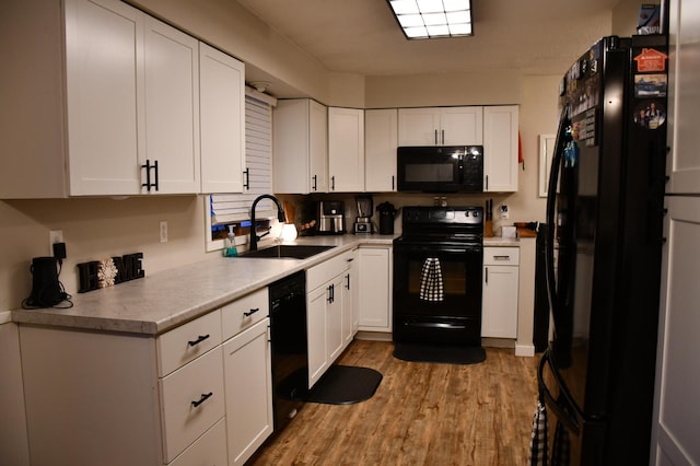 kitchen featuring black appliances, light hardwood / wood-style floors, white cabinetry, and sink