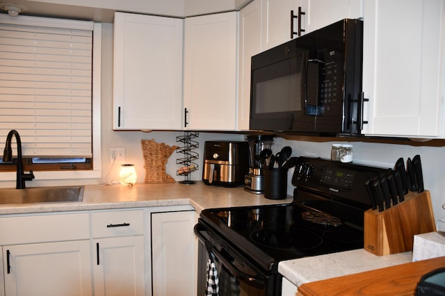 kitchen with white cabinetry, sink, and black appliances