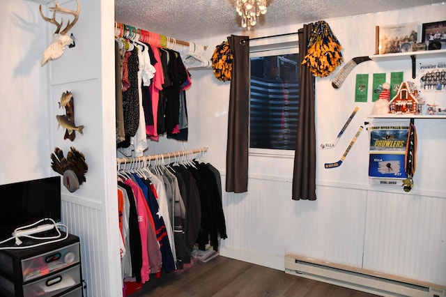 walk in closet with dark hardwood / wood-style floors and a baseboard heating unit