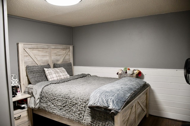 bedroom with dark hardwood / wood-style flooring and a textured ceiling