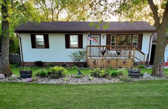 ranch-style house with a deck and a front lawn