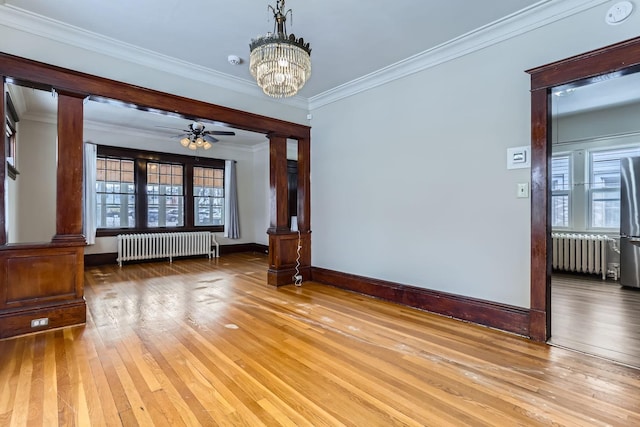 unfurnished room with ornate columns, crown molding, and radiator