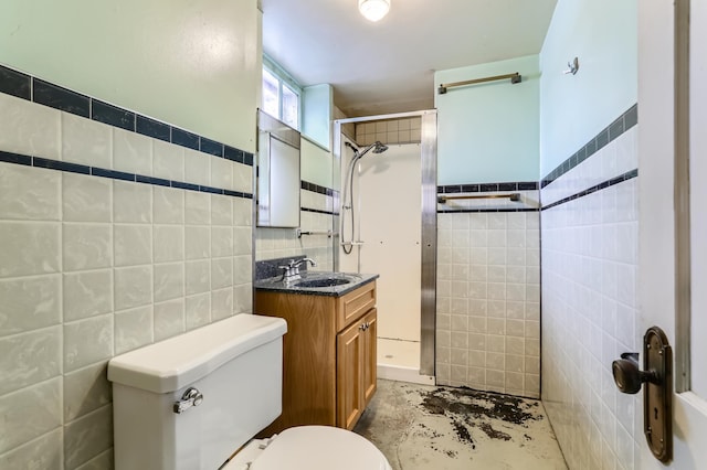 bathroom with vanity, toilet, tile walls, and a shower