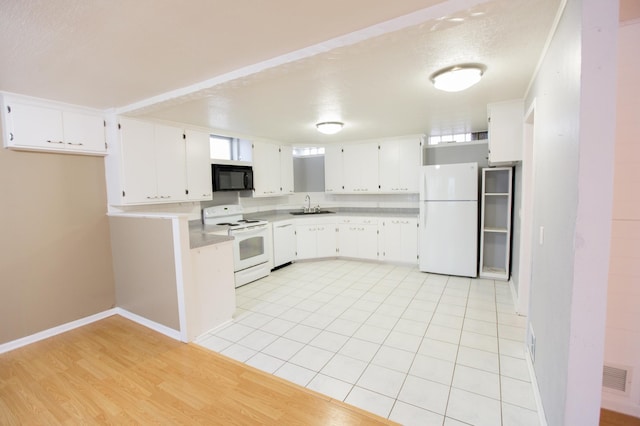 kitchen with white appliances, sink, light tile patterned floors, a textured ceiling, and white cabinetry