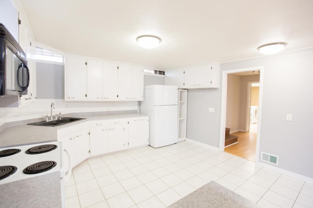 kitchen featuring white cabinets, light tile patterned floors, white appliances, and sink