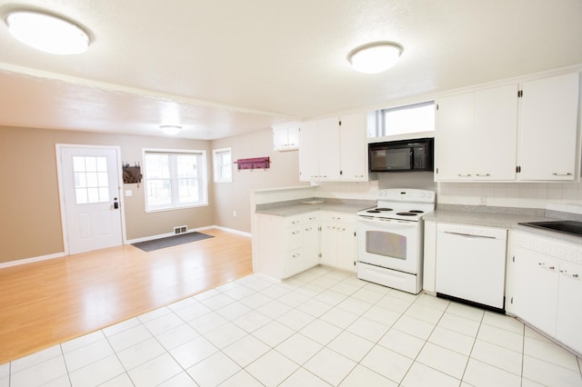 kitchen featuring white cabinetry, sink, light tile patterned floors, and white appliances