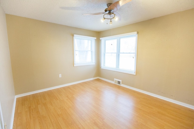 spare room with a textured ceiling, hardwood / wood-style flooring, and ceiling fan