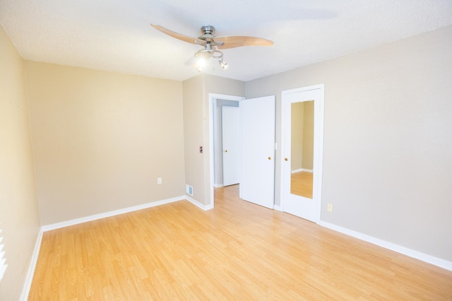 spare room featuring ceiling fan, light hardwood / wood-style floors, and a textured ceiling