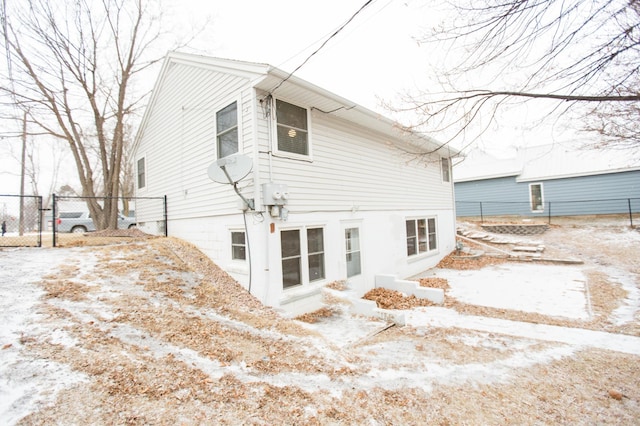 view of snow covered rear of property