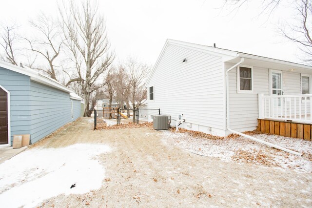 view of snow covered exterior with central AC unit