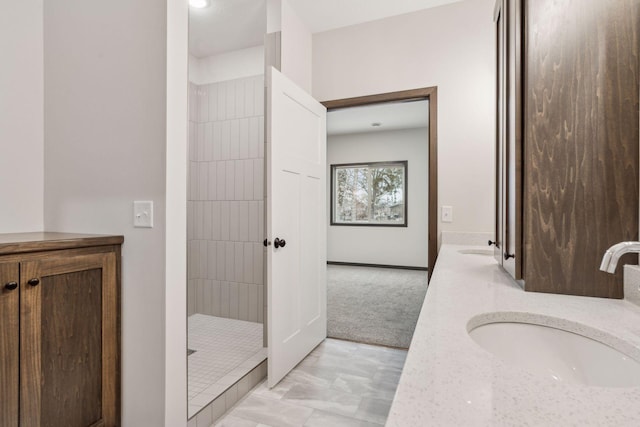 bathroom featuring a shower and vanity