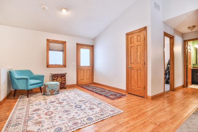 foyer entrance with light wood-type flooring and lofted ceiling