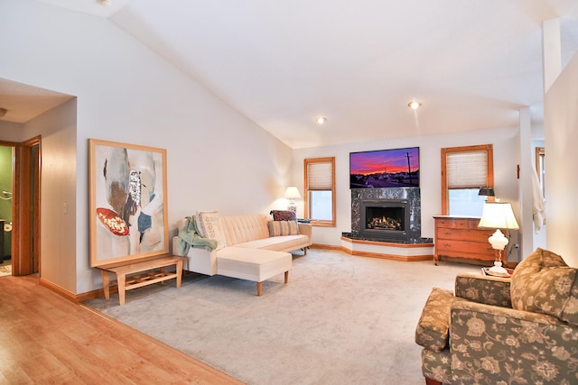 living room featuring a fireplace, hardwood / wood-style floors, and high vaulted ceiling