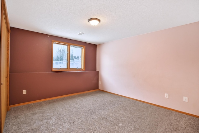 carpeted spare room featuring a textured ceiling