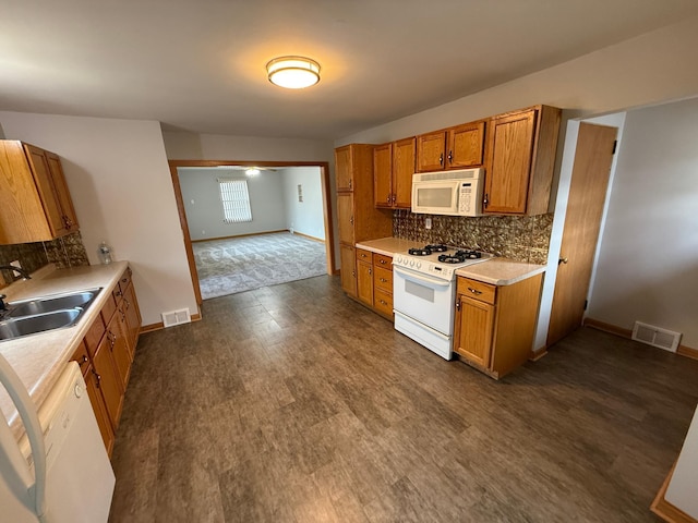 kitchen featuring decorative backsplash, white appliances, dark hardwood / wood-style floors, and sink