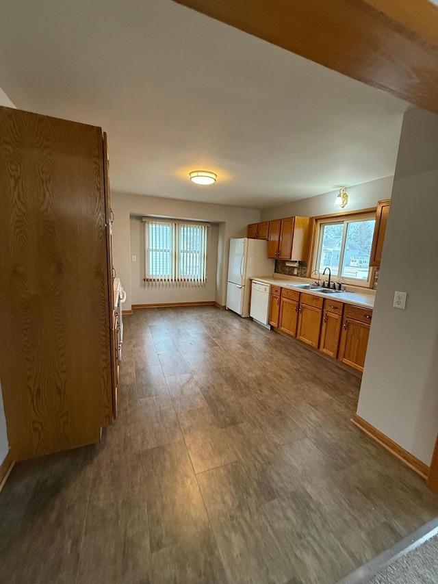 kitchen featuring dark hardwood / wood-style floors, white appliances, and sink