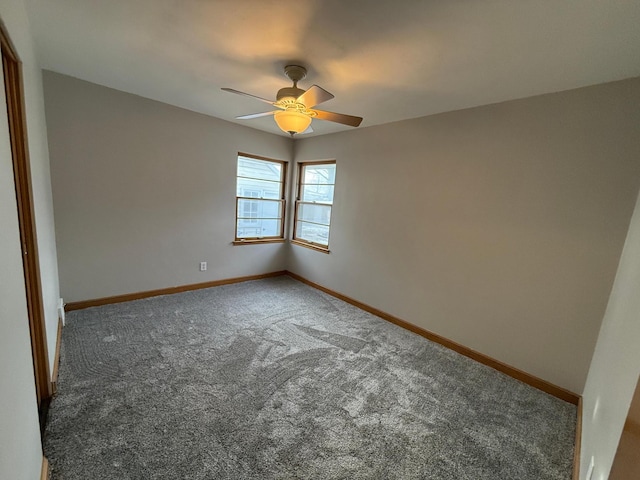 unfurnished room featuring ceiling fan and dark colored carpet