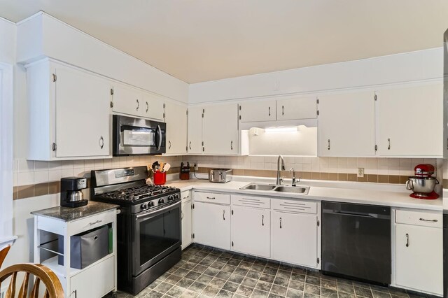 kitchen featuring white cabinets, black dishwasher, stainless steel gas range oven, and sink