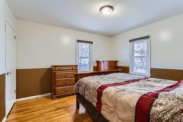 bedroom with light hardwood / wood-style flooring and multiple windows