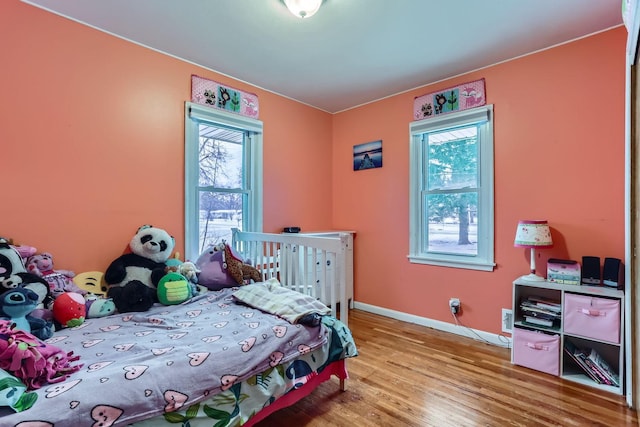 bedroom with light wood-type flooring and multiple windows