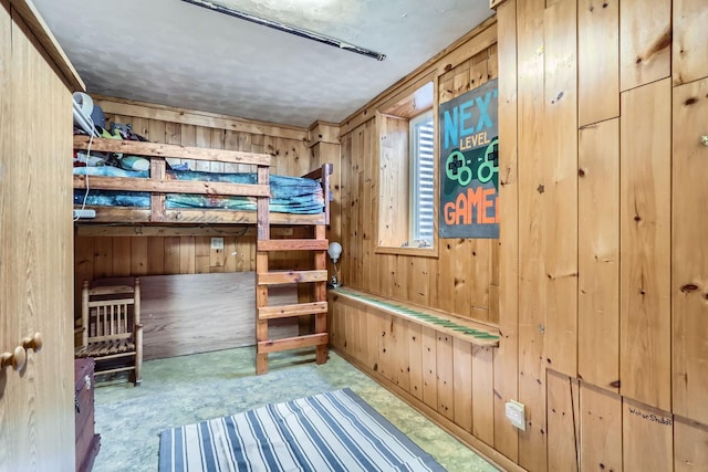 unfurnished bedroom with a textured ceiling and wood walls