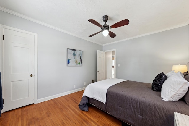 bedroom featuring ceiling fan, crown molding, and hardwood / wood-style floors