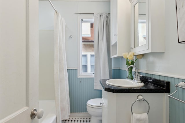 full bathroom with toilet, vanity, shower / tub combo, and wooden walls