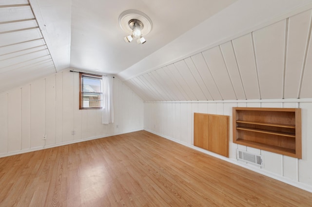 additional living space with light wood-type flooring and lofted ceiling