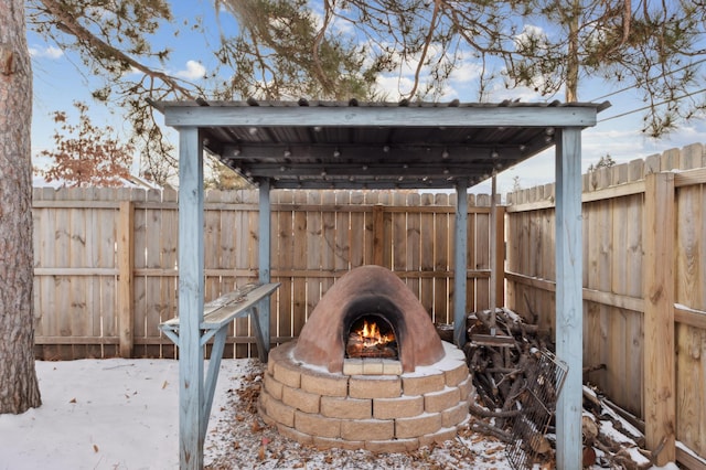 snow covered patio featuring a fire pit