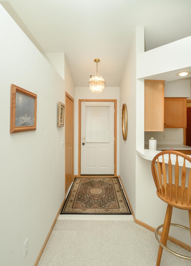 doorway to outside featuring carpet and a chandelier