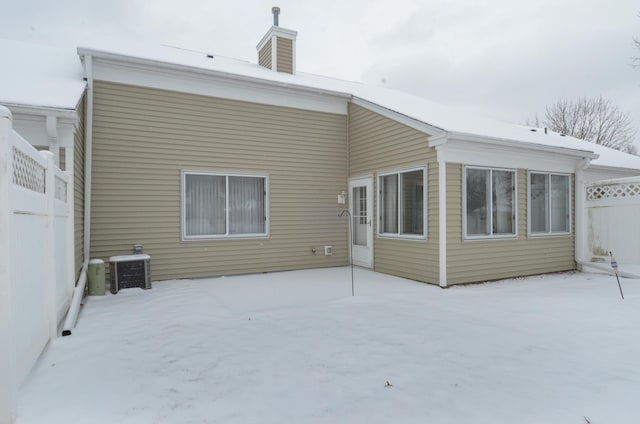 snow covered house featuring central AC