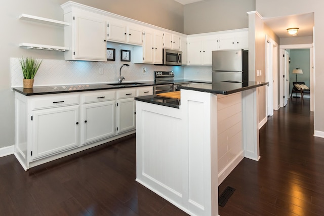 kitchen with stainless steel appliances, white cabinetry, and sink