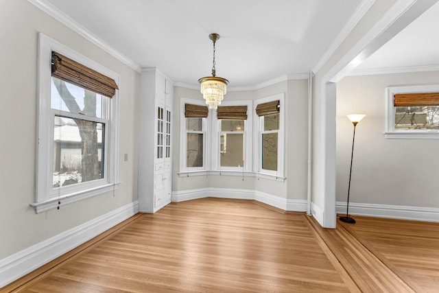 unfurnished dining area featuring crown molding, a notable chandelier, and light wood-type flooring