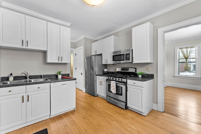 kitchen with sink, white cabinets, light wood-type flooring, and stainless steel appliances