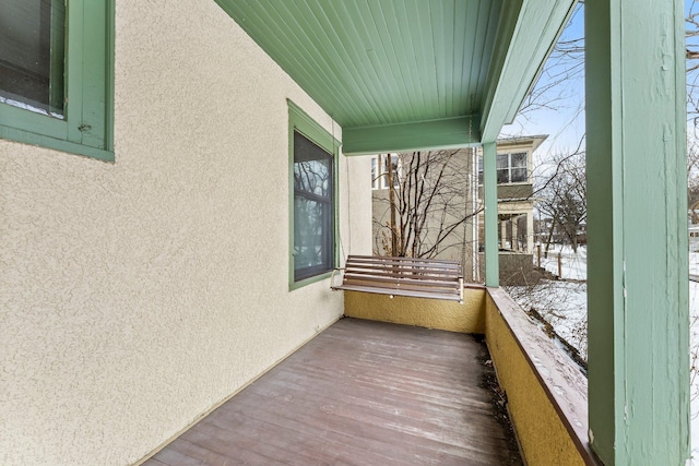 snow covered back of property with covered porch