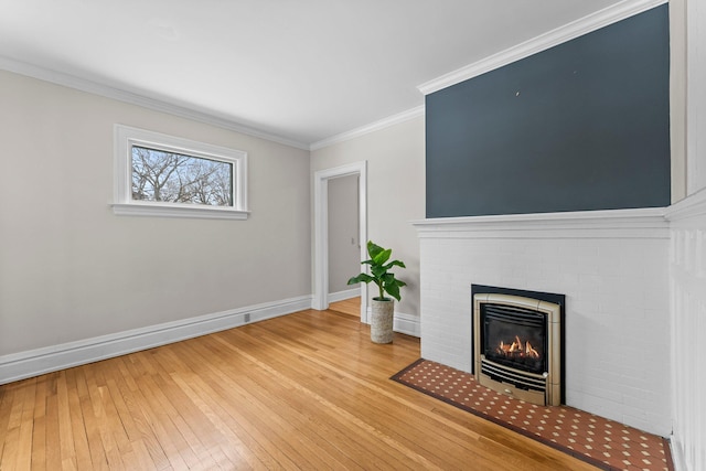 unfurnished living room featuring crown molding, hardwood / wood-style floors, and a brick fireplace