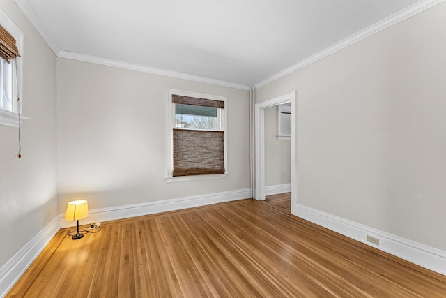 empty room with hardwood / wood-style flooring and ornamental molding