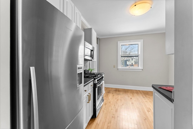 kitchen with ornamental molding, white cabinets, light hardwood / wood-style floors, and appliances with stainless steel finishes