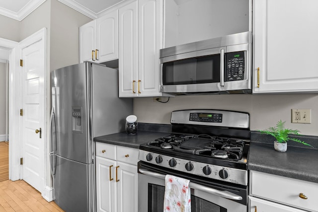 kitchen with white cabinets, stainless steel appliances, crown molding, and light wood-type flooring