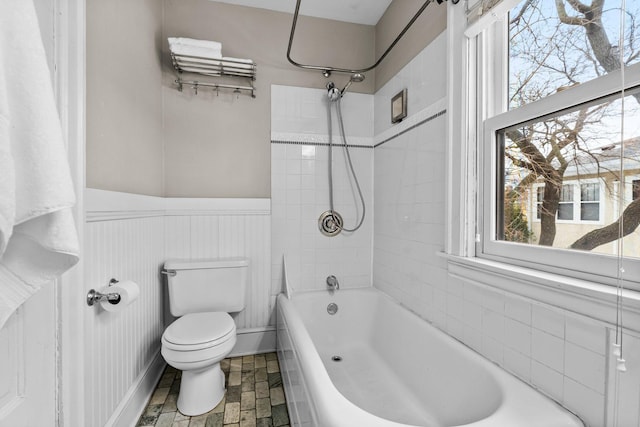 bathroom featuring toilet and tiled shower / bath combo