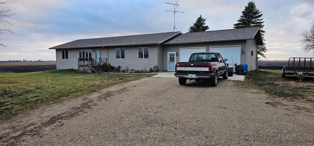 ranch-style house featuring a front lawn and a garage