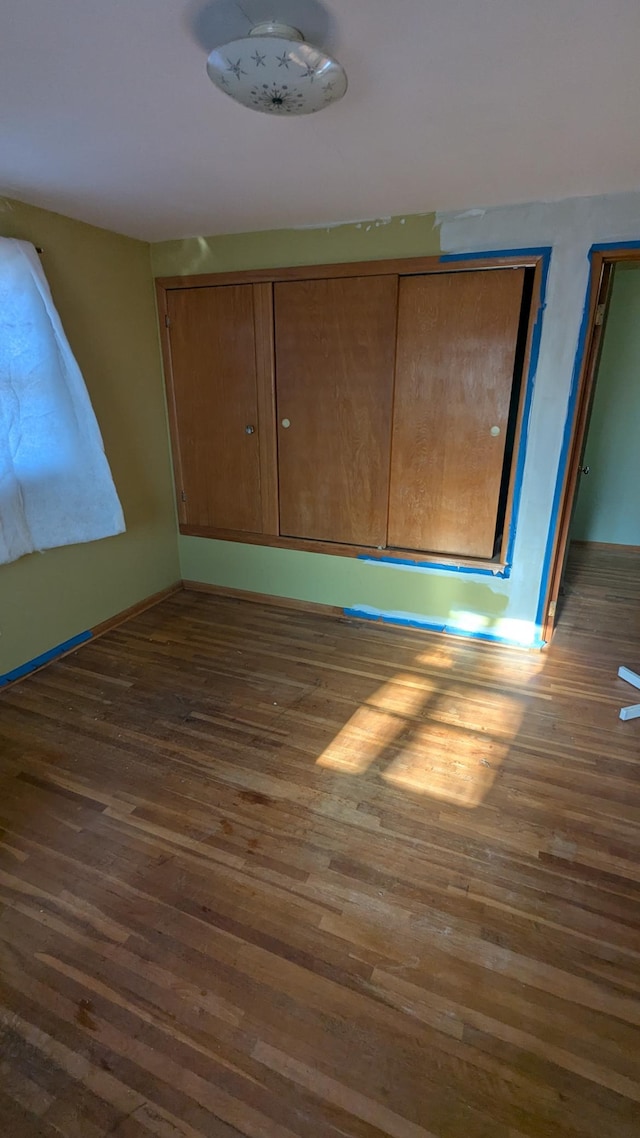 unfurnished bedroom with dark wood-type flooring