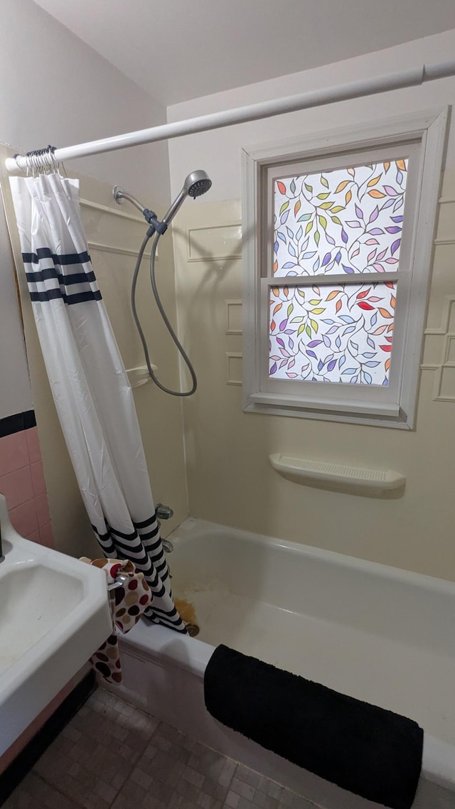 bathroom with plenty of natural light and shower / bathtub combination with curtain