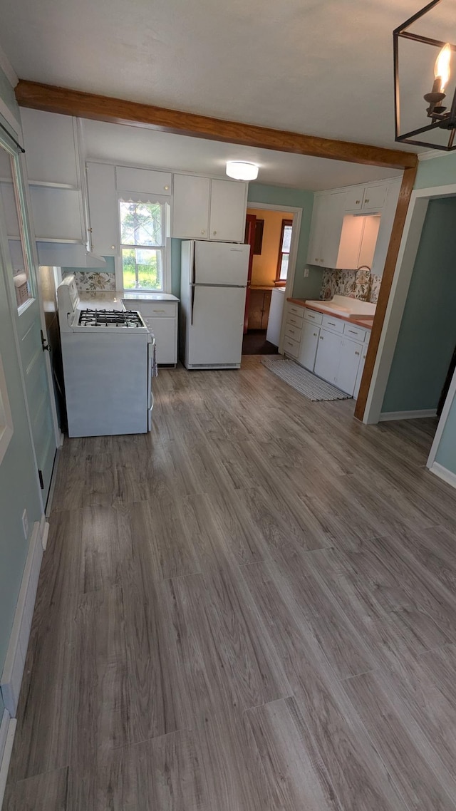 2114 5th Ave NE, Austin, MN 55912 - kitchen featuring white appliances, white cabinets, healthy amount of natural light, and dark wood-style flooring