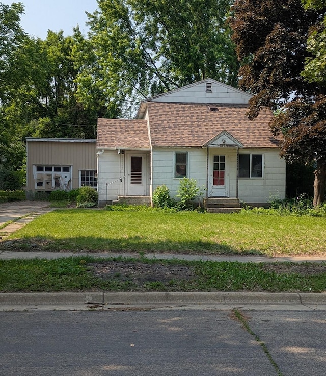 2114 5th Ave NE, Austin, MN 55912 - view of front facade with roof with shingles, a front yard, and entry steps