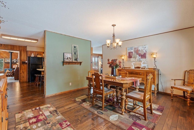 dining space with dark hardwood / wood-style flooring, a textured ceiling, and a notable chandelier